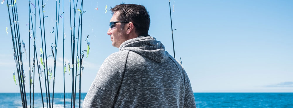 A man looking over the edge of a fishing boat